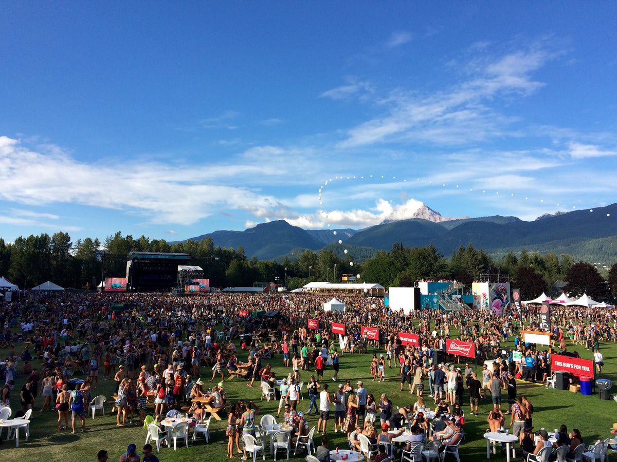 Squamish music festival with attendees, stages, and mountains in the background photographed from vip brand activation for Budweiser by Evelyn Martin. 