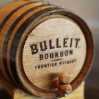 Bulleit Bourbon Frontier Whiskey barrel on a stand with a blurred background
