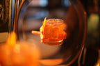 Cocktail in a glass with a lemon twist on a blurred bar background