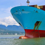 Container ship with a mountainous landscape in the background