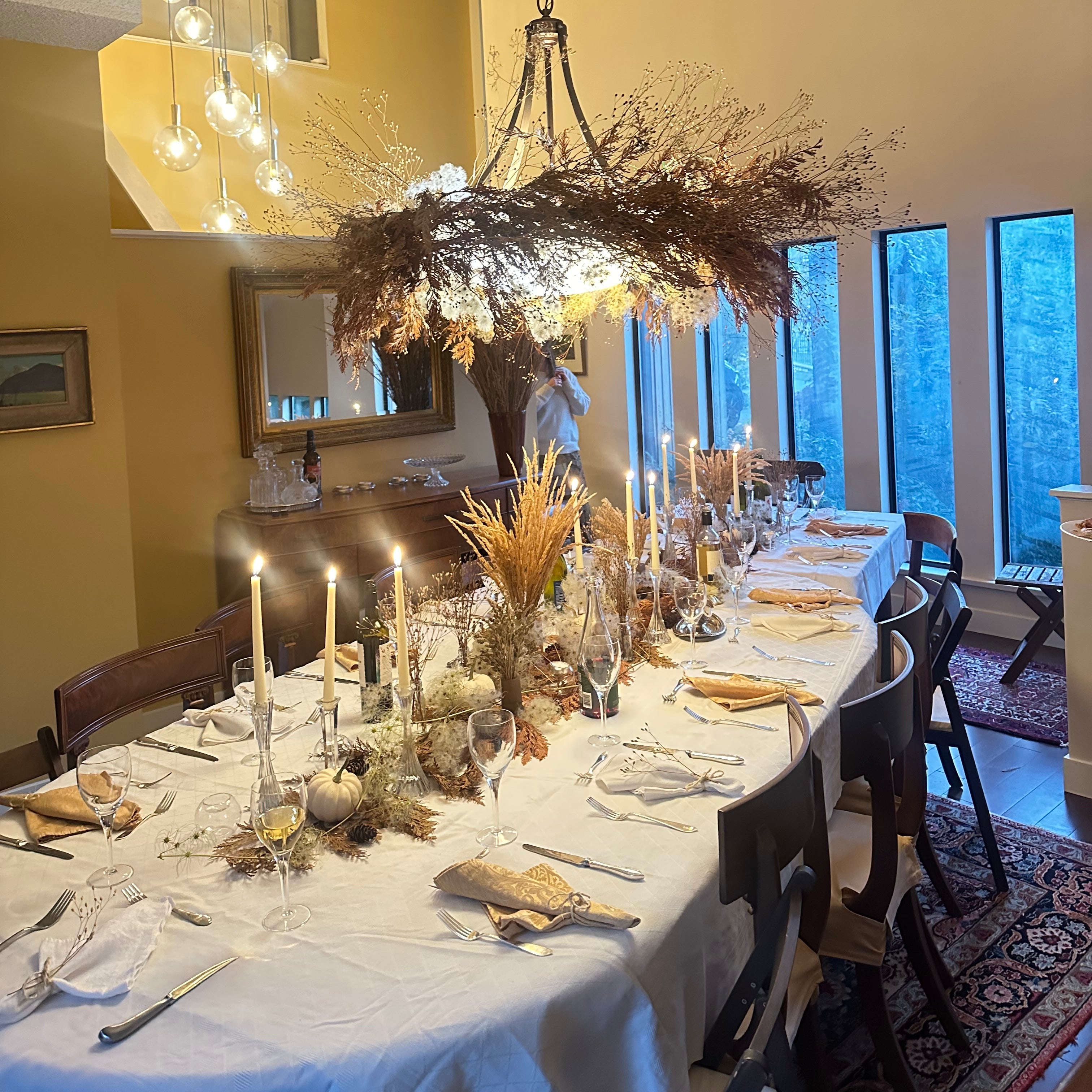 Elegant dining room with a table set for a meal, candles, and decorative elements, decorated by Evelyn & Susan Goodeve. 