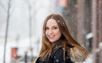 Evelyn Martin with long brown hair smiling outdoors for a fashion photoshoot in a snowy setting in Montreal