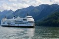 Ferry boat on a body of water with mountains in the background