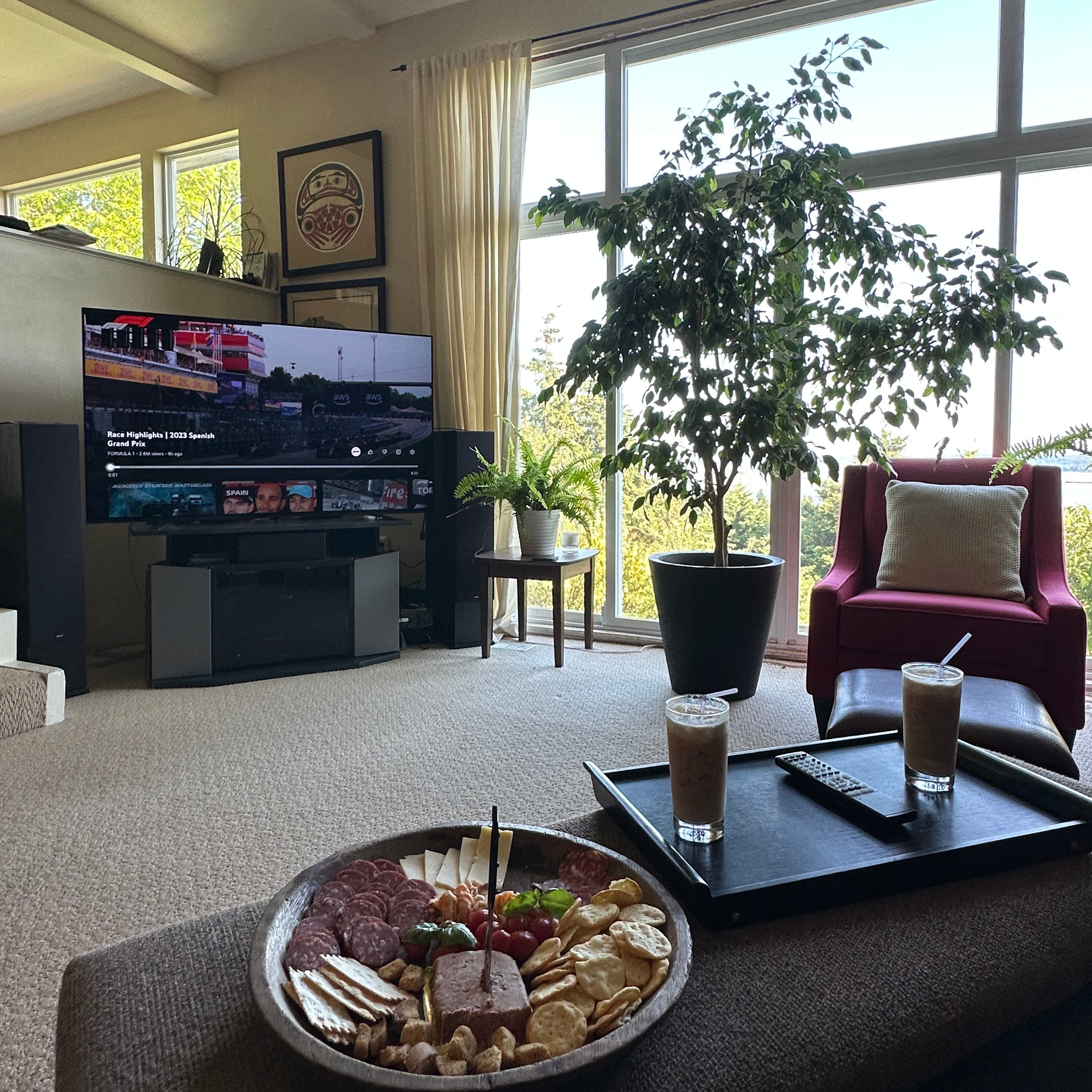 Living room with a TV, charcuterie board, and drinks on a coffee table.