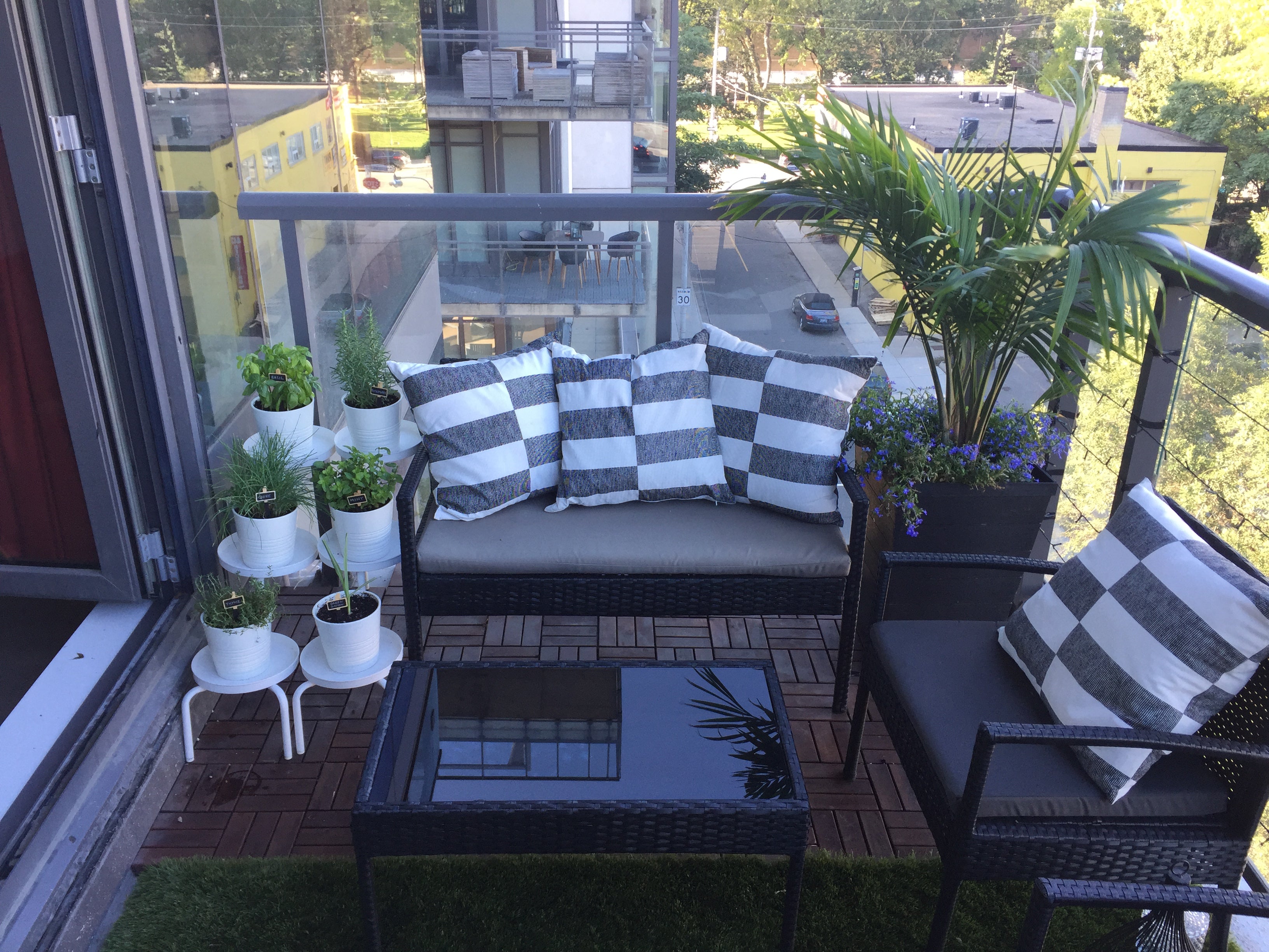 Balcony with outdoor furniture, cushions, and potted plants