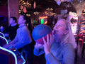 Susan playing a game at an arcade with a blue light effect