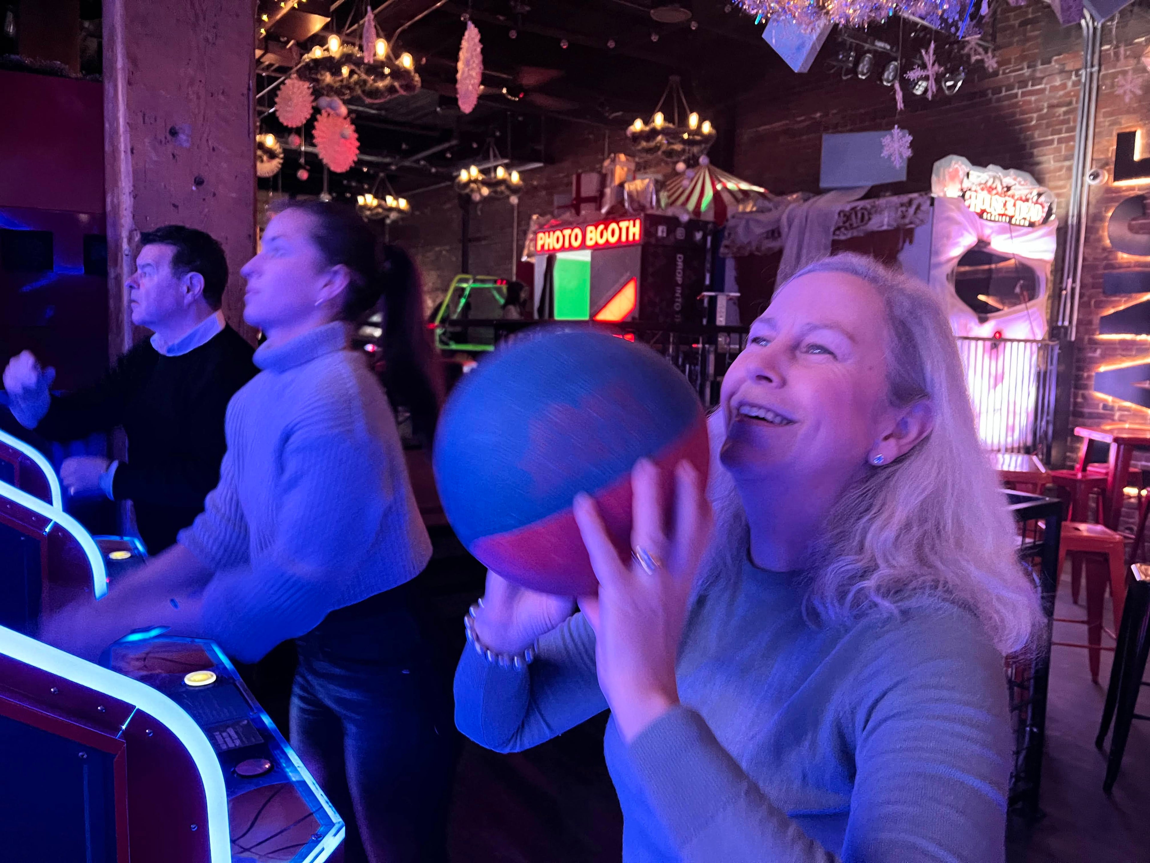 Susan playing a game at an arcade with a blue light effect