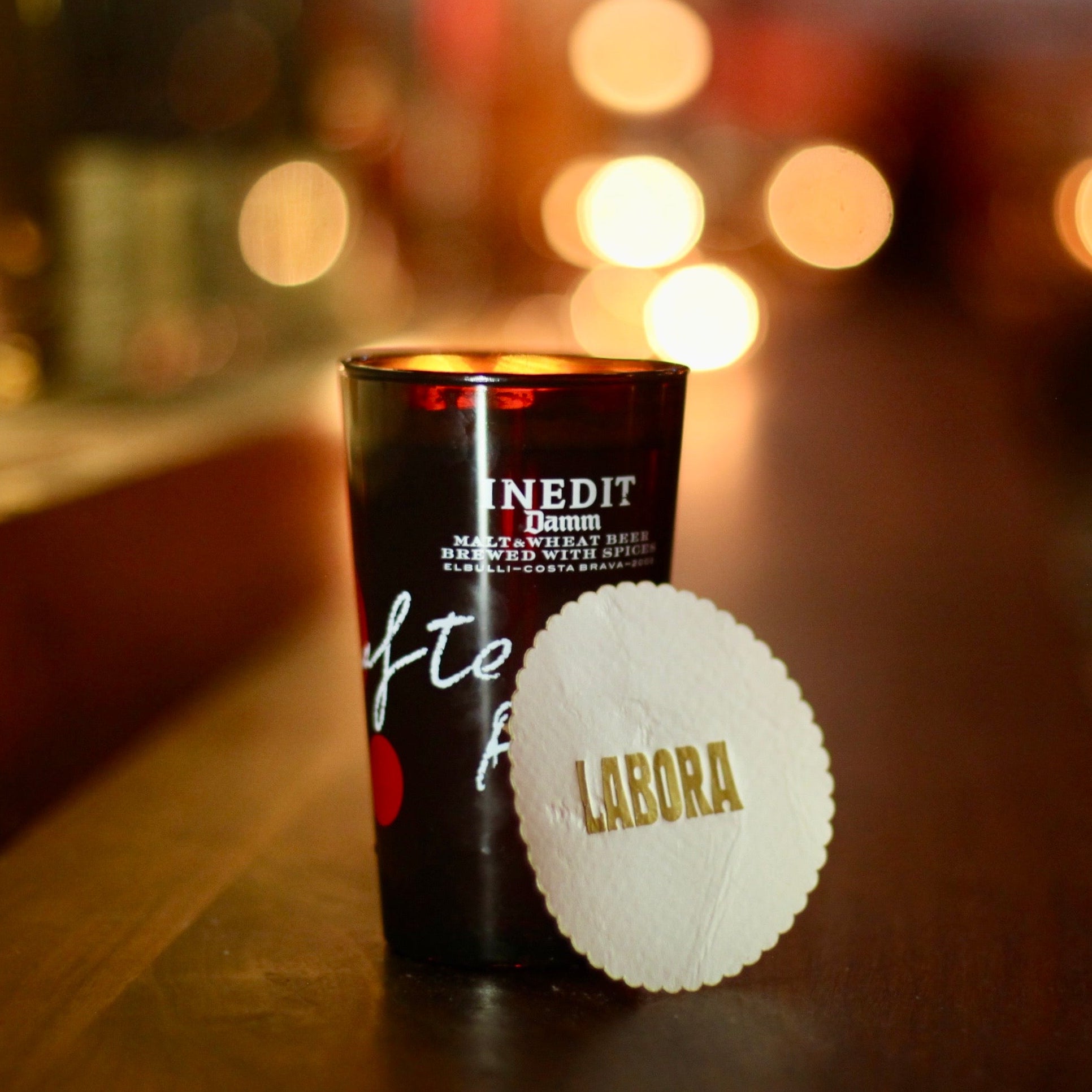 Black cup with white label on a bar counter with blurred lights in the background
