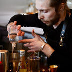 Barista preparing a drink with a focus on the coffee-making process.