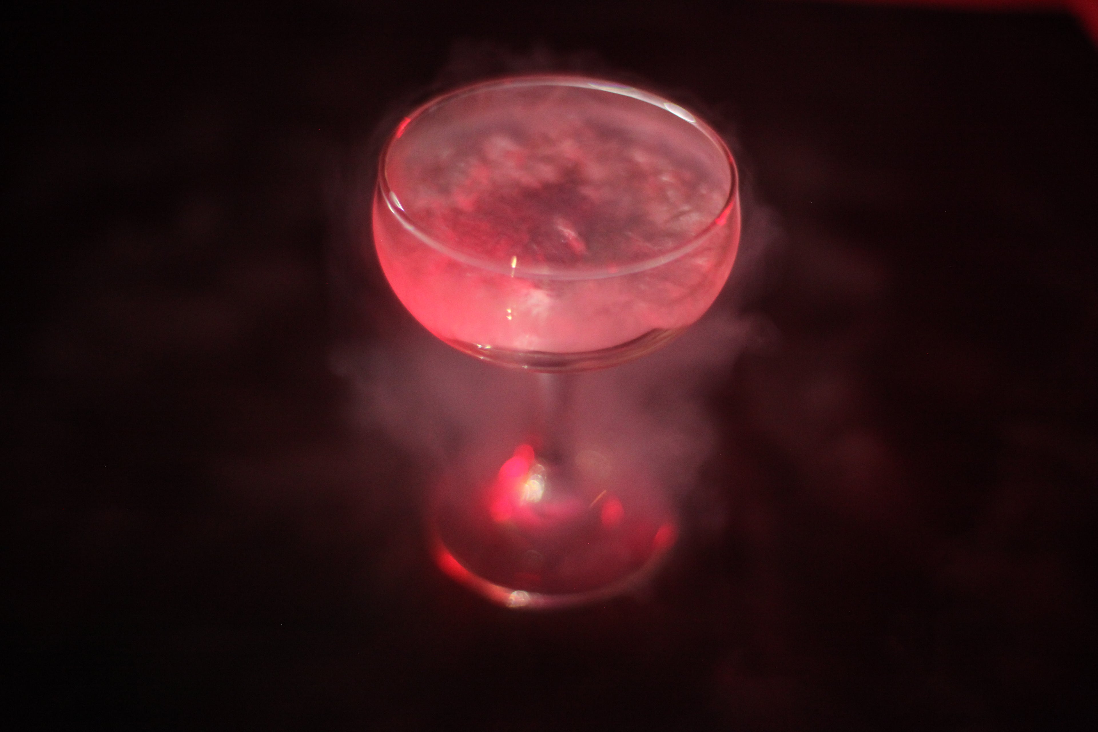 Red cocktail in a glass with a dark background