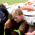 Rugby players in a scrum on a grass field