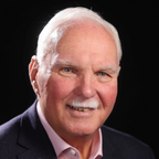 Man with a mustache wearing a suit against a black background