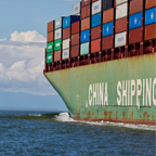 Container ship with 'China Shipping' on the side sailing on the ocean.
