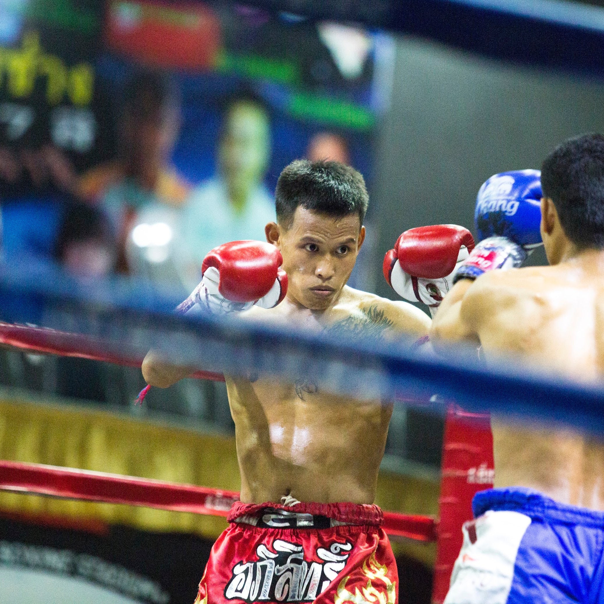 Two boxers in a boxing ring with a blurred background