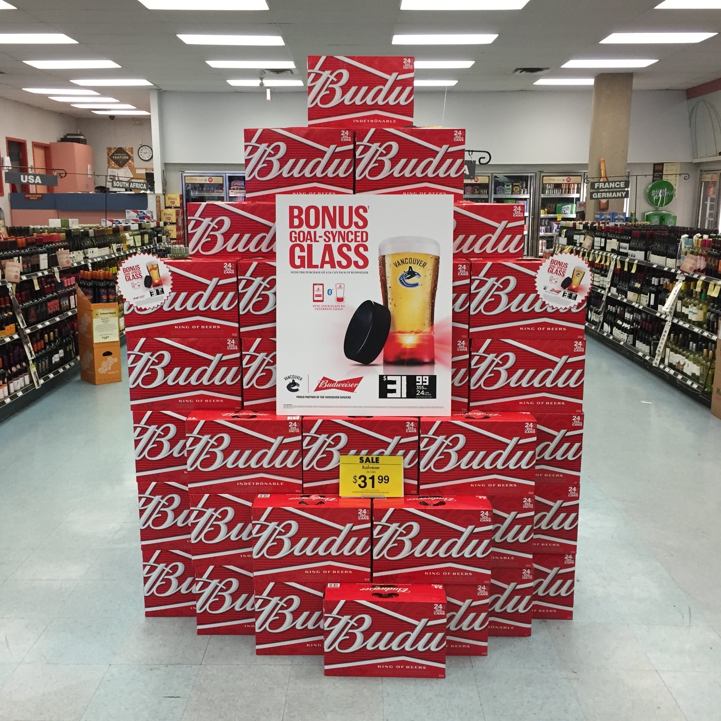 Budweiser Budlt display in a store with a bonus glass offer.