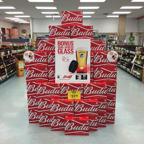 Budweiser Budlt display in a store with a bonus glass offer.
