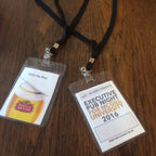 Two name badges on a wooden surface, one with Stella Artois logo and the other with McGill University event details.