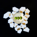 Cocktail with three green olives on a decorative coaster with a black background