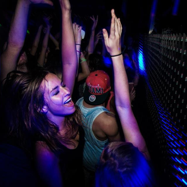People dancing in a dark room with blue lighting