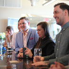 Group of people sitting at a bar, engaged in conversation.